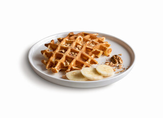 Belgian waffles with chopped nuts and pieces of banana on a plate, isolated on a white background. Close-up.
