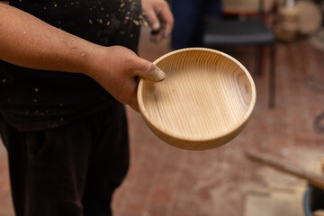 Man holding handmade wooden bowl in hand