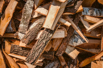 Close up of Large pile of birch wood. Remains of woodworking production stacked on the ground near the fence