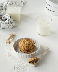 Oatmeal banana cookies with  chocolate drops on the white ceramic plate, glass of milk, milk jug....