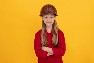 confident teen child in builder helmet on yellow background