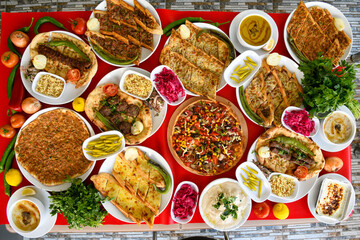 Traditional Turkish cuisine. Pizza, pita, pidesi, sucuk, hummus, kebab. Many dishes on the table. Serving dishes in restaurant. Background image. Top view, flat lay