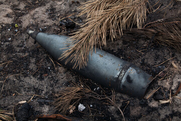An unexploded artillery shell on the ground