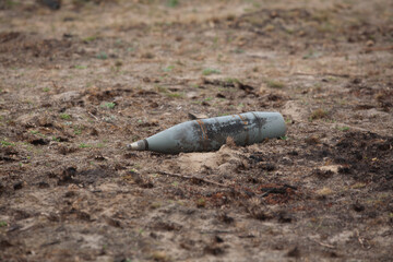 An unexploded artillery shell on the ground