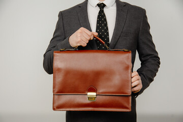 Close-up of businessman with briefcase in hand isolated on white background - obrazy, fototapety, plakaty