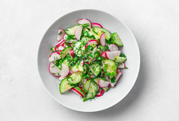 Salad with radish, cucumber and herbs. Vegetarian, diet salad. View from above.