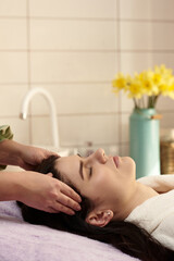 health and beauty, resort and relaxation concept - young woman in spa salon getting massage