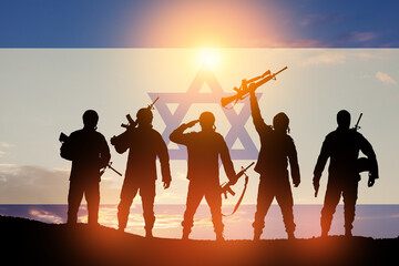 Silhouettes of soldiers against the sunrise in the desert and Israel flag. Concept - armed forces of Israel.