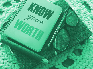 Know Your Worth word written in a notebook with pen and glasses. Business concept
