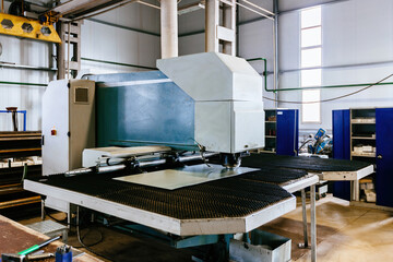 CNC punching and nibbling machine and perforated steel sheet, close up
