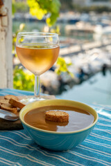 Homemade fish soup with croutons served with glass of cold rose wine and view on colorful fisherman's boats in harbour of Cassis, Privence, France.