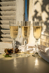 Three glasses of French champagne sparkling wine and view on colorful fisherman's boats in old harbour in Cassis, Provence, France