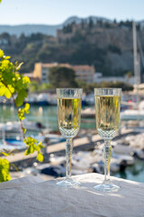 Birthday celebration with two glasses of French champagne sparkling wine and view on colorful fisherman's boats in old harbour in Cassis, Provence, France
