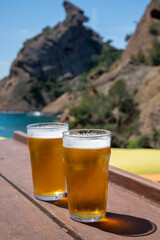 Two glasses of fresh cold lager beer served outdoor in snack bar with view on Calanque de Figuerolles in La Ciotat, Provence, France