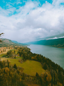 Cloudy Columbia river with green pastures and trees