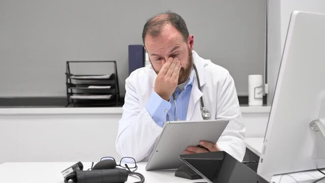 Doctor looking worried a x-ray image at digital tablet, checking the results of a medical examination. High quality 4k footage