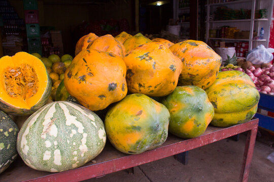 group of ripe papayas and a pumpkin with daylight