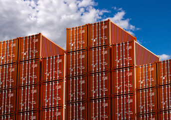 Warehouse of cargo containers. Red cargo containers on background of sky. Lots of shipping containers on top of each other. Metal boxes for ship transportation. Warehouse in seaport. 3d rendering.