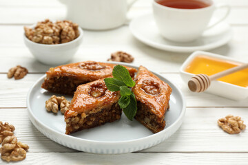 Delicious sweet baklava with walnuts and mint on white wooden table