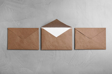 Simple brown paper envelopes on light grey table, flat lay