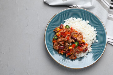 Plate of rice with chili con carne on light grey table, flat lay. Space for text