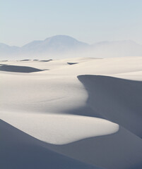Fototapeta na wymiar Gypsum sand dunes in White Sands National Park with blowing sand in the distance
