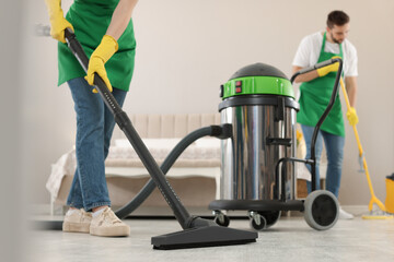 Professional janitors working in bedroom, closeup. Cleaning service