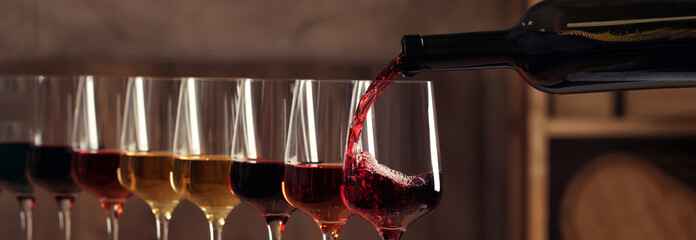 Pouring wine from bottle into glass. Banner design