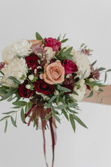 Wedding bouquet in bright colors. Red rose, cappuccino rose, eucalyptus, dianthus