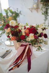 Large gift arrangement with bright red and white flowers and ribbons