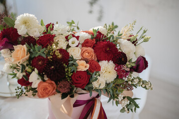 Large gift arrangement with bright red and white flowers and ribbons
