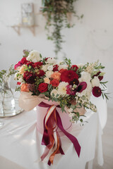 Large gift arrangement with bright red and white flowers and ribbons