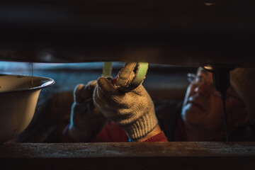 Mechanic under car changing oil filter.