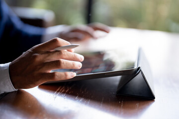 Close up of man's hand using a pen and a laptop.