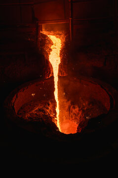 A stream of molten slag is poured into a metallurgical ladle