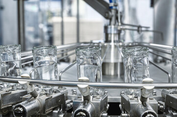 Bottles of vodka upside down transported by conveyor