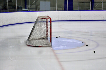 Ice Hockey Net with pucks in front of it