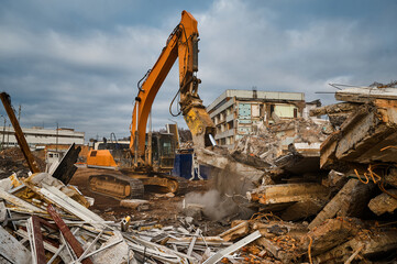 Fototapeta premium Excavator destroyer with hydraulic scissors cuts concrete