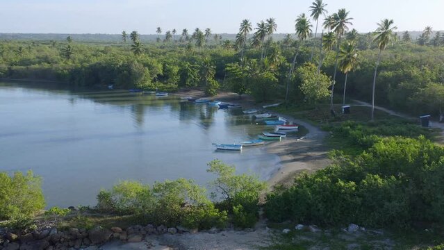 Wooden boats on beach at Soco river mouth, Dominican Republic. Aerial circling