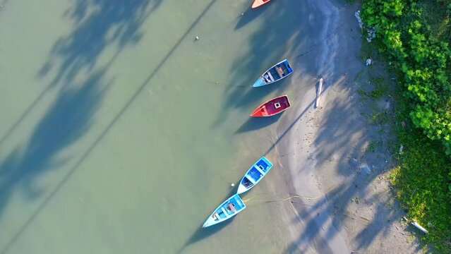 Aerial top-down forward over colorful boats at Soco river mouth, Dominican Republic