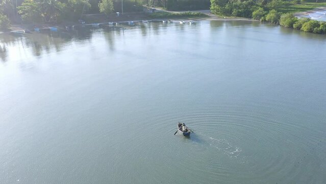 Fisherman on boat in Soco River mouth with fishing criminal method, Dominican Republic. Aerial circling