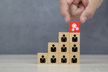 Hand choose cube wooden block stack with lightbulb on human icon stack in pyramid for leadership and business team creative thinking and human resources for teamwork or team player.