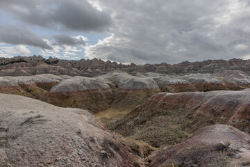 Clouds form over a colorful landscape of ravines at Badlands National Park in South Dakota