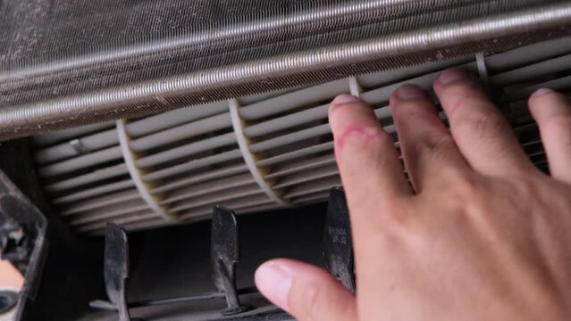 Worker cleaning dirty air conditioner blower fan and cooling coil. The blower of the dusty indoor air conditioner, close-up. The concept of cleanliness and hygiene in the home.