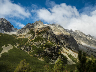 Fototapeta na wymiar Panoramic view of the autumn mountains. Green and yellow granite mountains against a blue sky with clouds