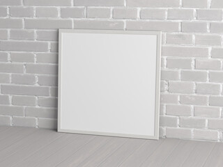 Mock up of square white frame on the floor with white brick wall.