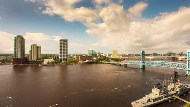 A Timelapse of clouds rolling across the St. Johns River in Downtown Jacksonville, Florida while boats race around the water and traffic crosses the bridges.