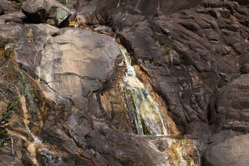 Fototapeta na wymiar 岩肌を流れ落ちる小さな滝