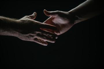 Fototapeta na wymiar Handshake. Men holding hands isolated on black. Connection and human relations. Male hands rescue. Friendly handshake, friends greeting, friendship. Rescue, helping gesture or hands. Helping hand.