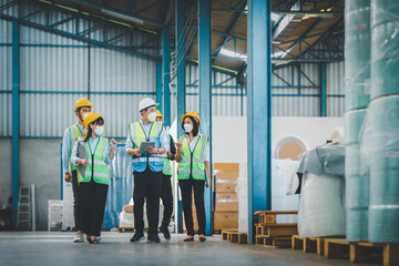 Manufacturing staff or worker in medical mask working together at factory